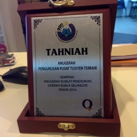 Wooden plaque award with engraved silver plate displaying Tahniah certificate in Malay, recognizing educational achievement in 2014
