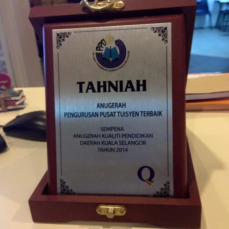 Wooden plaque award with silver nameplate reading Tahniah in Malay, recognizing best education center quality 2014
